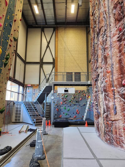 Commercial air cleaner controlling chalk dust and airborne particulate matter inside a climbing gym to protect the health and safety of climbers and staff.