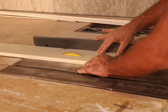 Woodworker creating custom cabinetry while OX1100 air cleaner eliminates airborne wood dust.