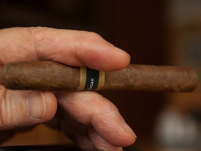 A hand holding a cigar in a commercial space, highlighting the need for smoke and odor removal.